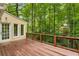 Wooden deck with brown railing overlooking a lush green forest at 355 Highlands Trce, Roswell, GA 30075