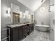 Bright bathroom with dual vanity, granite countertops, large mirrors, modern lighting, stand alone tub at 355 Highlands Trce, Roswell, GA 30075
