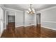 Dining room features dark hardwood flooring, crown molding, and a classic chandelier at 355 Highlands Trce, Roswell, GA 30075