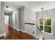 Bright hallway with hardwood floors and modern light fixture leads to other areas of the home at 355 Highlands Trce, Roswell, GA 30075