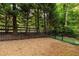 Backyard with wood chip groundcover surrounded by a black metal fence at 576 Cliftwood Ct, Sandy Springs, GA 30328