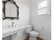 Bathroom featuring a pedestal sink and a toilet, all bathed in soft natural light from the window at 576 Cliftwood Ct, Sandy Springs, GA 30328