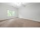 Neutral bedroom features neutral carpeting and a large window with views of the surrounding trees at 576 Cliftwood Ct, Sandy Springs, GA 30328