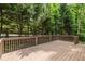 Outdoor deck with wood railing surrounded by mature trees, offering serene privacy at 576 Cliftwood Ct, Sandy Springs, GA 30328