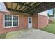 Back porch with door and window, brick exterior, and concrete floor, perfect for outdoor relaxation at 112 Tara Blvd, Loganville, GA 30052