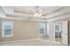 Bedroom featuring tray ceilings, natural light, and an attached bathroom with a door at 112 Tara Blvd, Loganville, GA 30052