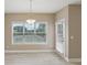 Bright dining area features neutral walls, stylish chandelier, and natural light from large window at 112 Tara Blvd, Loganville, GA 30052