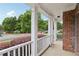 Charming front porch with classic white railings and an exterior brick wall overlooking a manicured lawn at 112 Tara Blvd, Loganville, GA 30052