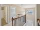 Upstairs hallway featuring a wood banister and views of the home's entrance at 112 Tara Blvd, Loganville, GA 30052