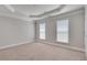 A spacious bedroom with neutral carpet, tray ceiling and two windows allowing ample natural light at 2325 Limehurst Ne Dr, Atlanta, GA 30319