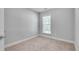 This bedroom has neutral carpeting and paint and a window for natural light at 2325 Limehurst Ne Dr, Atlanta, GA 30319