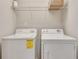 Functional laundry room with white washer and dryer, and shelving above at 2325 Limehurst Ne Dr, Atlanta, GA 30319