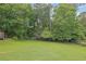 Expansive backyard with lush greenery is surrounded by mature trees and partial fencing at 2149 New London Place Pl, Snellville, GA 30078