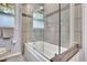 Modern bathroom featuring a bathtub with clear glass doors and tiled walls with a decorative mosaic border at 2149 New London Place Pl, Snellville, GA 30078