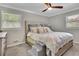 Cozy bedroom with plush bedding, ceiling fan, and natural light from two windows at 2149 New London Place Pl, Snellville, GA 30078