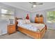 Bright bedroom with natural wood furniture, large windows, and light purple walls and neutral carpeting at 2149 New London Place Pl, Snellville, GA 30078