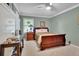 Cozy bedroom with a wooden sleigh bed, a nightstand with a lamp, and neutral-toned walls and carpeting at 2149 New London Place Pl, Snellville, GA 30078