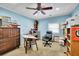 Spacious home office with blue walls, a ceiling fan, a desk, and ample storage and display space at 2149 New London Place Pl, Snellville, GA 30078