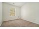 This is a compact bedroom with neutral carpeting, window, and light-colored walls at 234 Riverstone Commons Cir, Canton, GA 30114