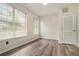 Bedroom with sleek, wood-look flooring, white walls and trim, and a door to a closet at 234 Riverstone Commons Cir, Canton, GA 30114