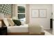 Comfortable bedroom featuring accent wallpaper, neutral decor, and natural light from the large window at 2464 Cotton Ln, Douglasville, GA 30135