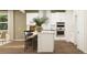 Bright kitchen with a central island, stainless steel appliances, modern white cabinetry, and wood flooring at 2464 Cotton Ln, Douglasville, GA 30135
