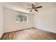 Bright bedroom featuring wood floors, a modern ceiling fan, and a large window providing plenty of natural light at 2948 Sagewood Dr, Snellville, GA 30039