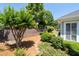 Landscaped backyard with stone retaining wall and fresh green lawn, shrubs and mature trees at 6350 Manningtree Ct, Cumming, GA 30041