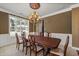 Elegant dining space with a large window, chandelier, and a dark wood dining set at 6350 Manningtree Ct, Cumming, GA 30041