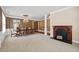 Open concept dining area with wood fireplace, chandelier, and decorative columns and wainscoting at 6350 Manningtree Ct, Cumming, GA 30041
