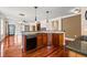 Kitchen featuring granite counters, wood cabinets, with sink and island at 6350 Manningtree Ct, Cumming, GA 30041