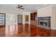 Living room featuring hardwood floors, built in shelving, and stone fireplace at 6350 Manningtree Ct, Cumming, GA 30041