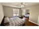 Cozy bedroom featuring hardwood floors, a large window, and mirrored closet at 1972 Brittania Cir, Woodstock, GA 30188