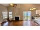 Cozy living room with fireplace, hardwood floors, and open layout to the kitchen and patio at 1972 Brittania Cir, Woodstock, GA 30188