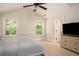 Comfortable bedroom featuring a ceiling fan, plush carpeting, and large windows at 2521 Livingston Ct, Loganville, GA 30052
