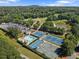 Aerial view of tennis courts, pool, parking lot, and pond surrounded by trees at 5706 Brookstone Nw Walk, Acworth, GA 30101
