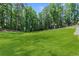 Expansive backyard with lush green grass surrounded by trees, providing a serene and private outdoor space at 5706 Brookstone Nw Walk, Acworth, GA 30101