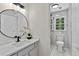 Bright bathroom with a modern vanity, a sleek round mirror, and a walk-in shower at 5706 Brookstone Nw Walk, Acworth, GA 30101