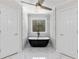 Modern bathroom features a free standing tub, white marble accents and decorative window between and closets at 5706 Brookstone Nw Walk, Acworth, GA 30101
