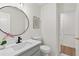 Clean half bathroom features a round mirror, light gray vanity, white walls, and dark fixtures at 5706 Brookstone Nw Walk, Acworth, GA 30101