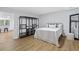 Modern bedroom featuring light wood floors, a bed with white quilt, and an open closet system at 5706 Brookstone Nw Walk, Acworth, GA 30101