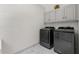 Functional laundry room with gray cabinets and modern washer and dryer at 5706 Brookstone Nw Walk, Acworth, GA 30101