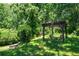 Secluded backyard with a wooden pergola featuring an outdoor lounge area and mature trees at 805 Gertrude Nw Pl, Atlanta, GA 30318