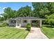 Single-story home with well-manicured lawn, attached carport, and lush trees at 805 Gertrude Nw Pl, Atlanta, GA 30318