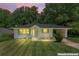 Charming single-story home with a well-manicured lawn and attached carport at dusk at 805 Gertrude Nw Pl, Atlanta, GA 30318