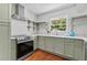 Well-lit kitchen with stainless steel range, sink beneath large window, and open shelving at 805 Gertrude Nw Pl, Atlanta, GA 30318