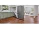 Modern kitchen with stainless steel appliances and sage green cabinetry next to living room at 805 Gertrude Nw Pl, Atlanta, GA 30318