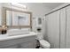 Neutral bathroom features a vessel sink, gray vanity, decorative mirror, and shower with neutral curtain at 4771 N Springs Nw Rd, Kennesaw, GA 30144
