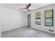 Bright bedroom featuring plush carpet, a modern ceiling fan, and views through a pair of windows at 4771 N Springs Nw Rd, Kennesaw, GA 30144