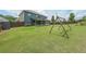 Wide backyard featuring lush green grass, a covered patio, a swing set, and privacy fencing at 5789 Creek Indian Dr, Sugar Hill, GA 30518